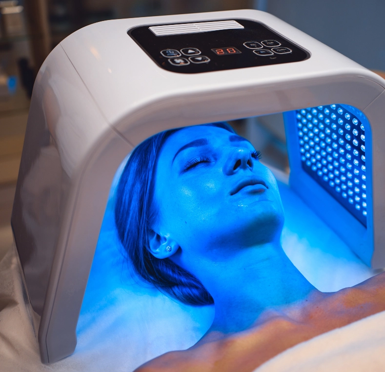Patient receiving blue light therapy treatment in a specialized dermatological device